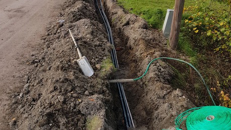 Utgrävning för nedläggning av fiber till bredband i marken.